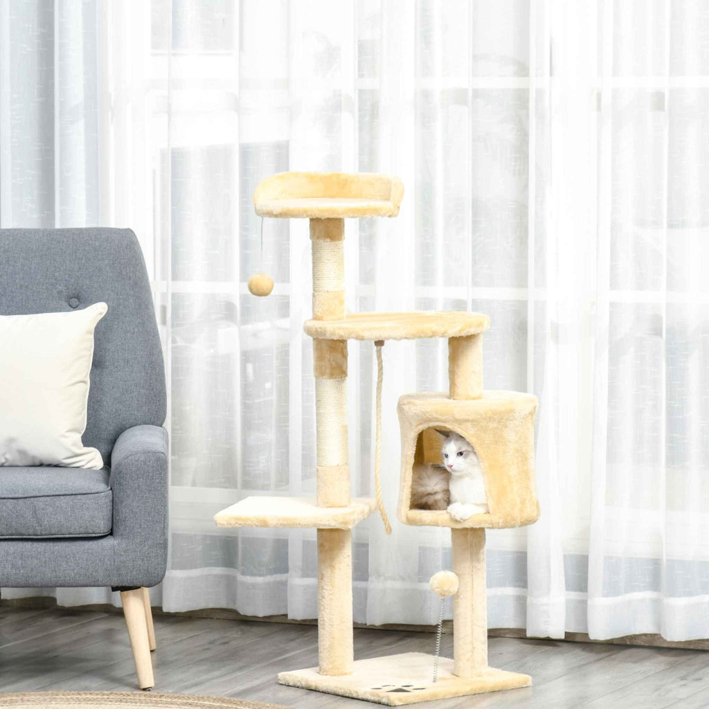 Beige multi level cat tree in living room with cat sitting in cat house