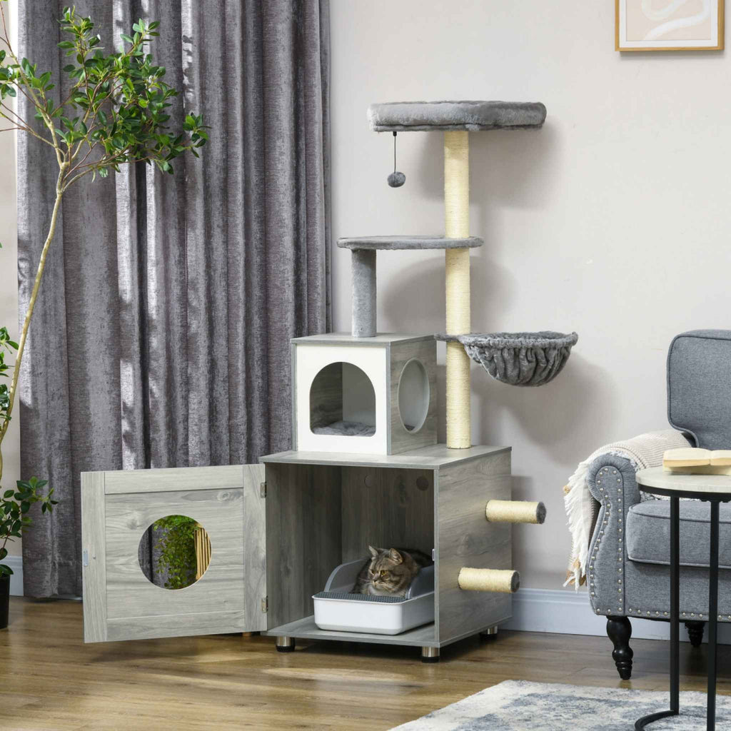 Cat in litter box within cat tree enclosure