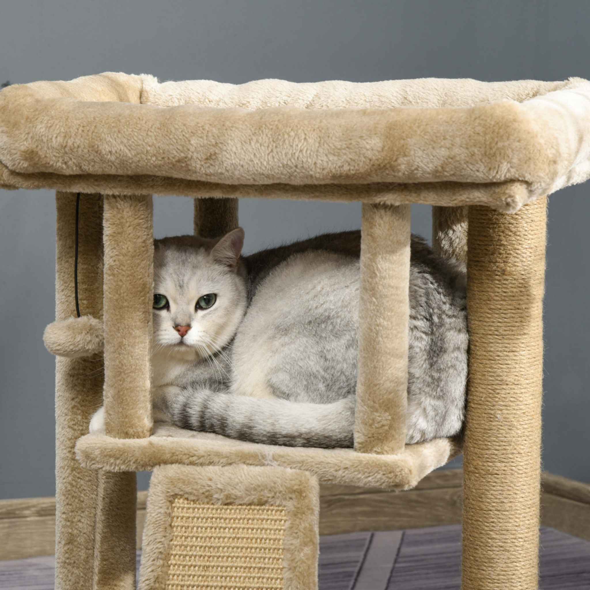 Cat laying on second level of beige cat tree