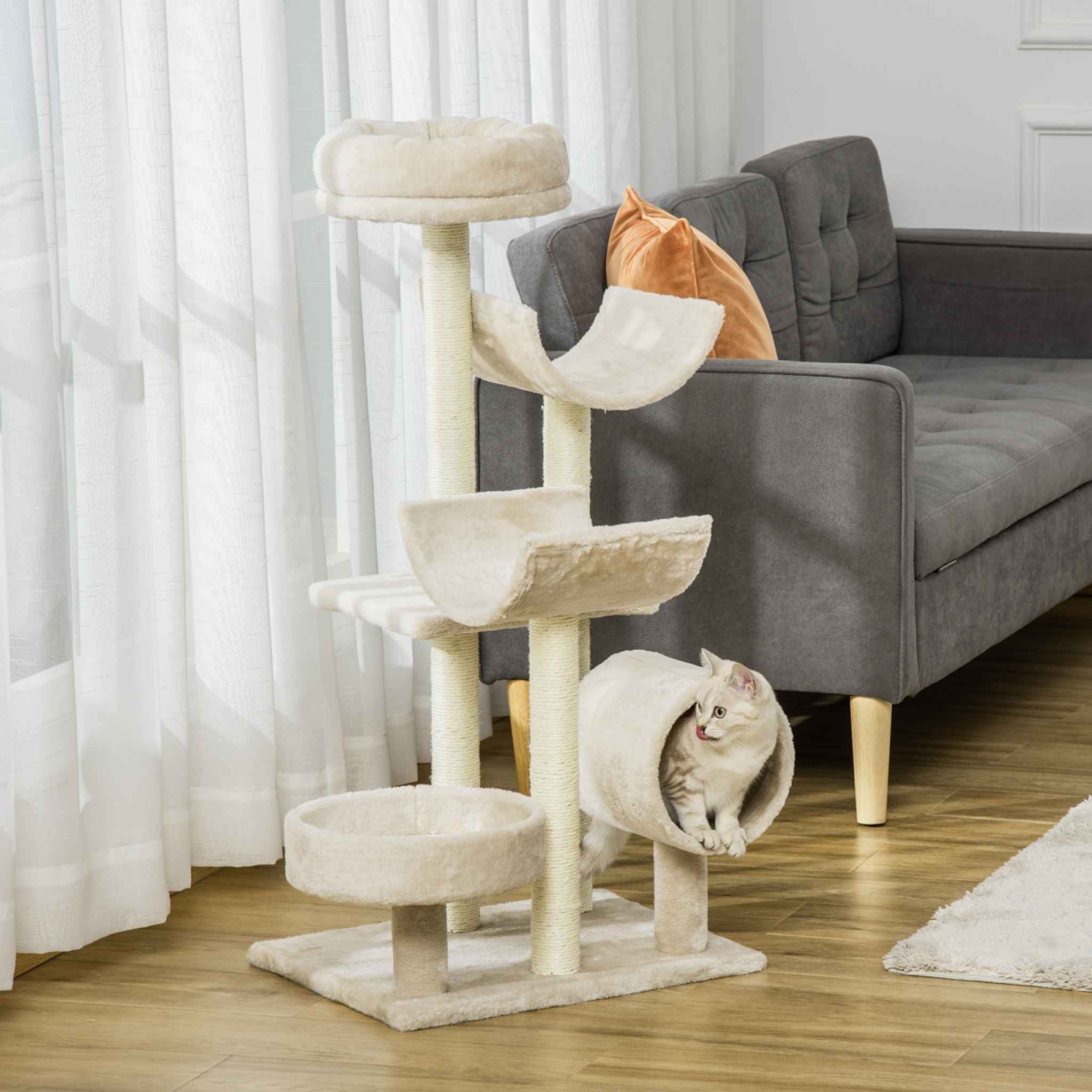 Cat resting in tunnel on cream cat tower