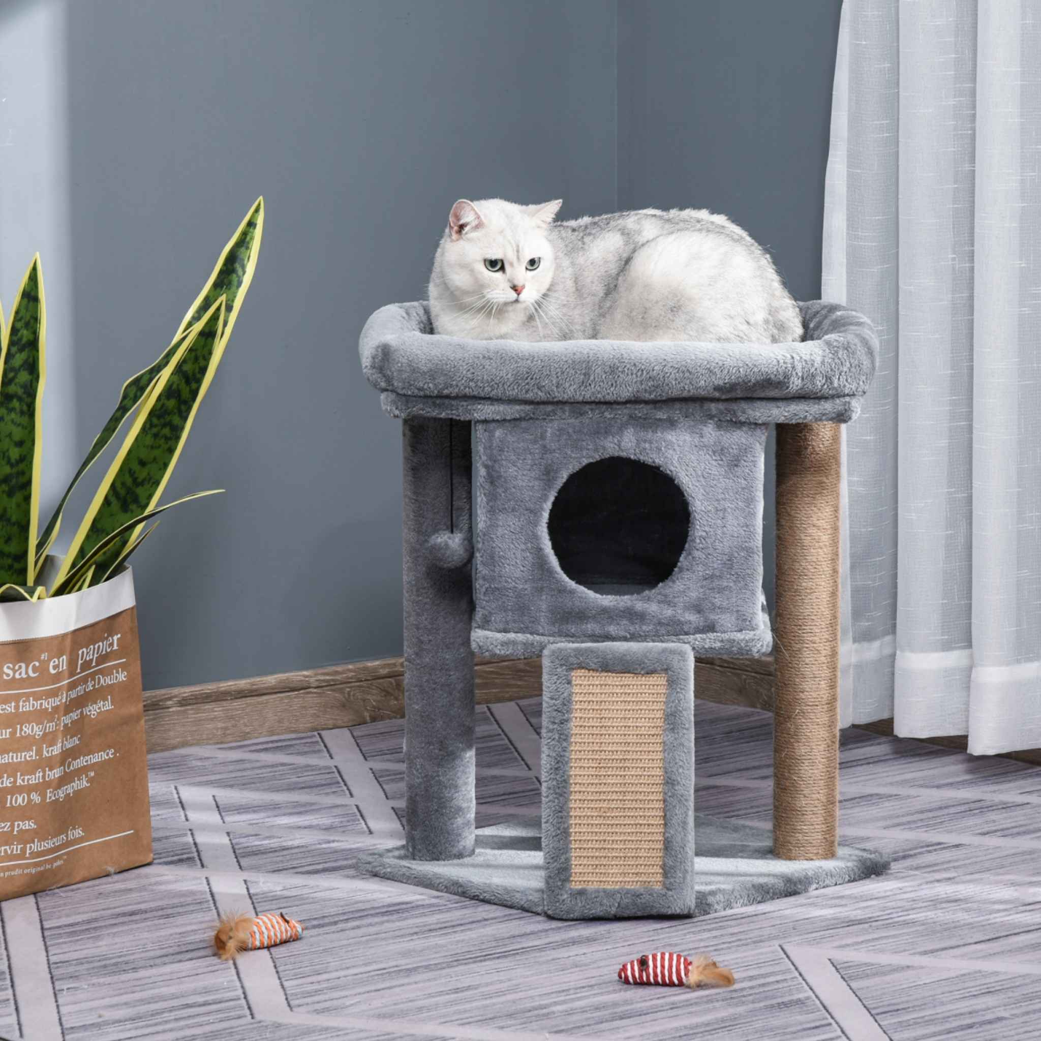 Cat resting on top perch of small grey cat tree