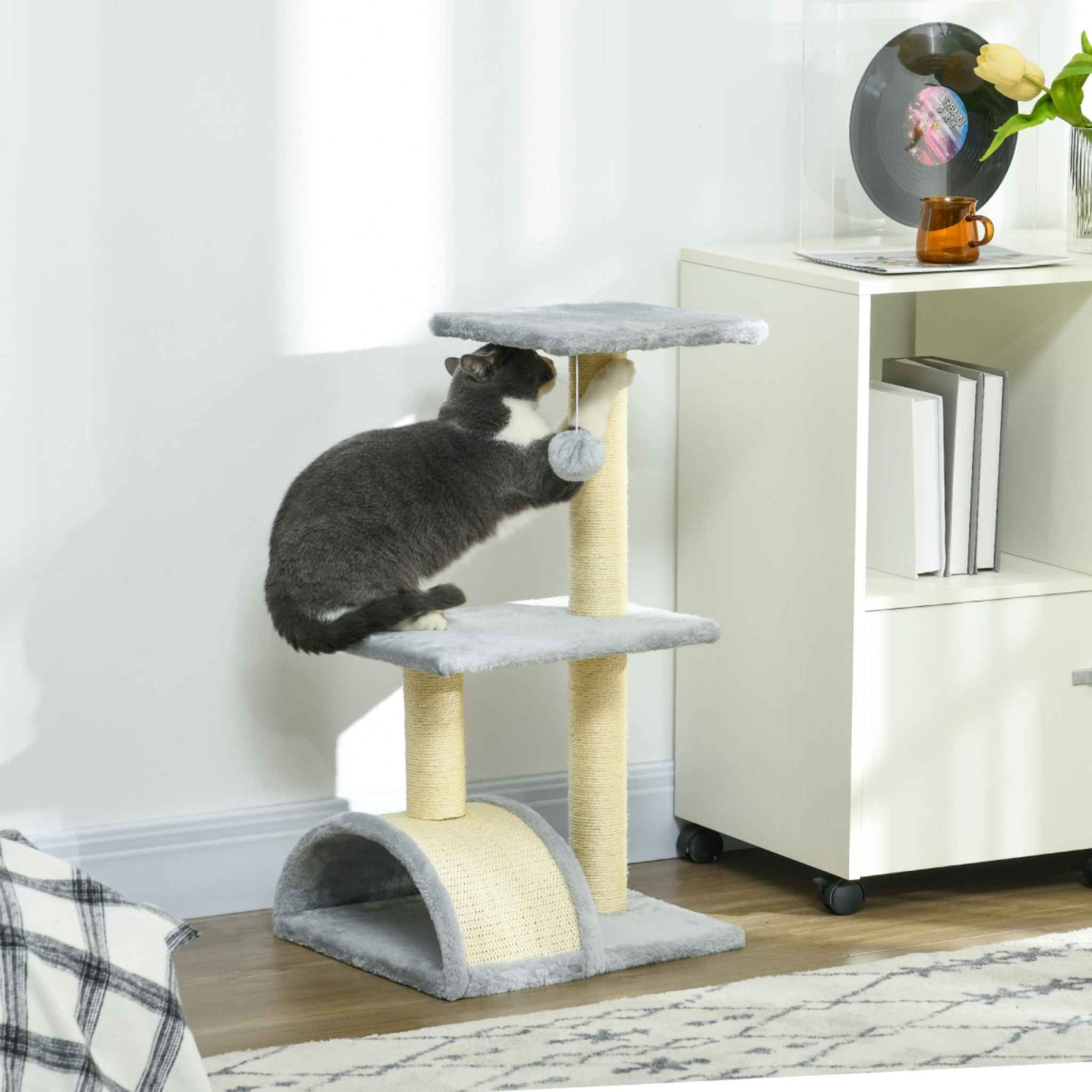 Cat scratching on top level of light grey cat tree