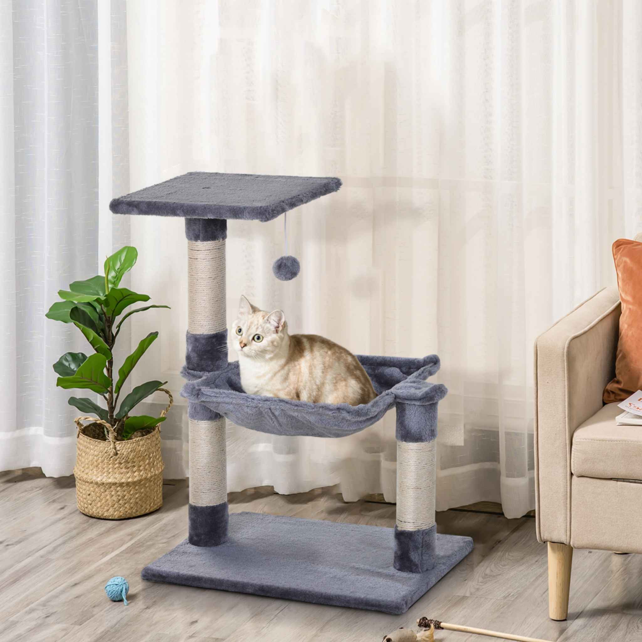 Cat sitting in hammock on grey cat tree