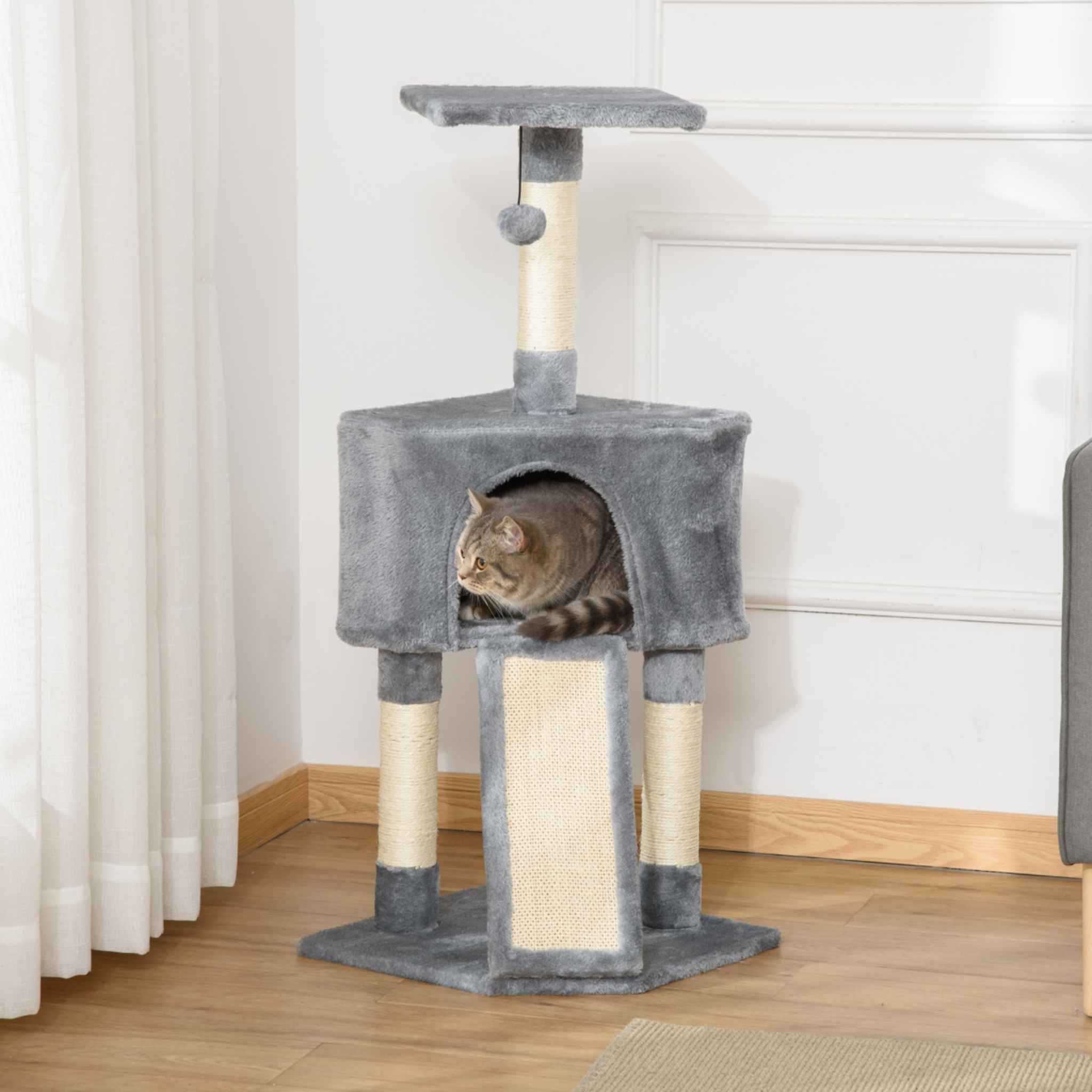 Cat sitting in house on grey cat scratching tower