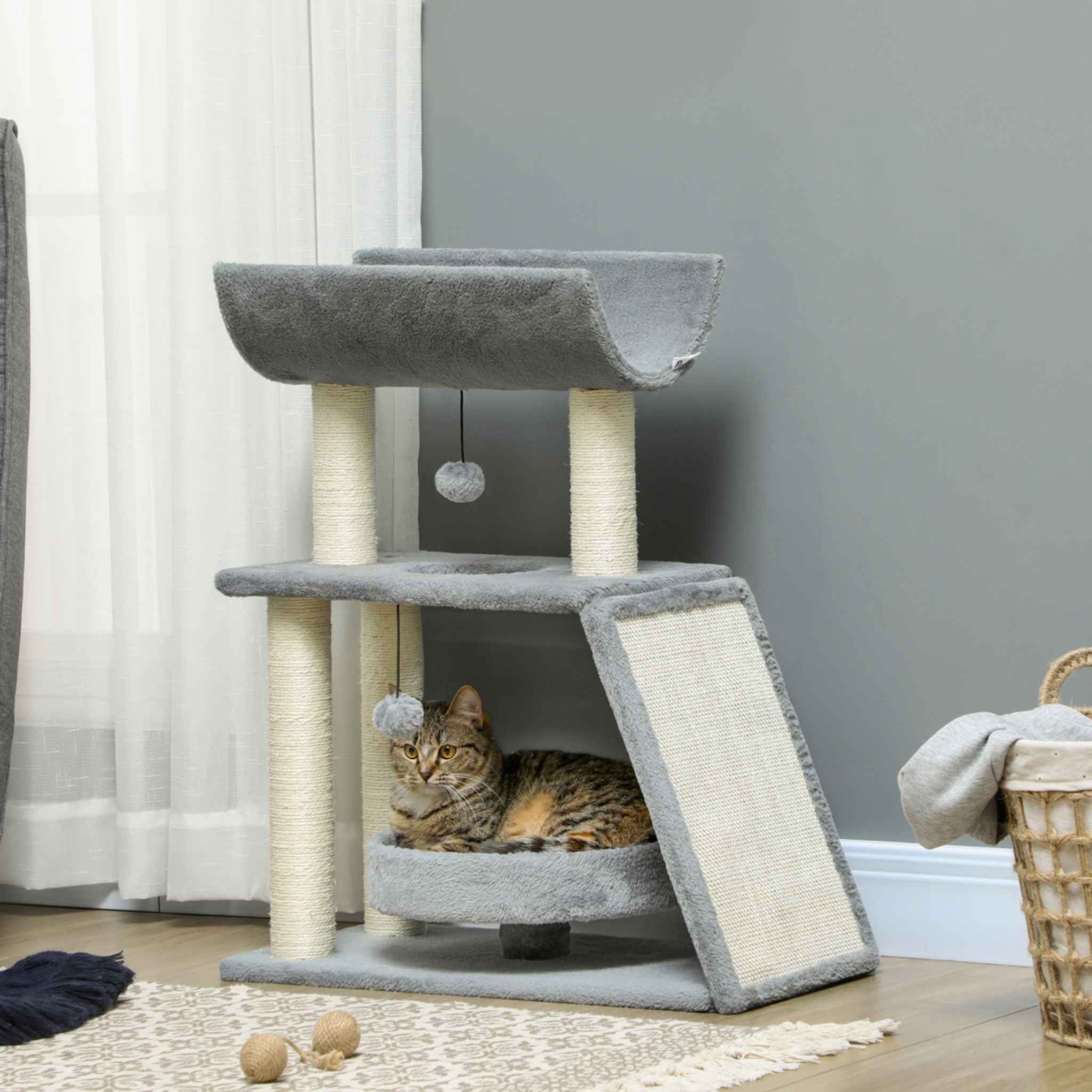 Cat sitting in raised bed within grey cat tower
