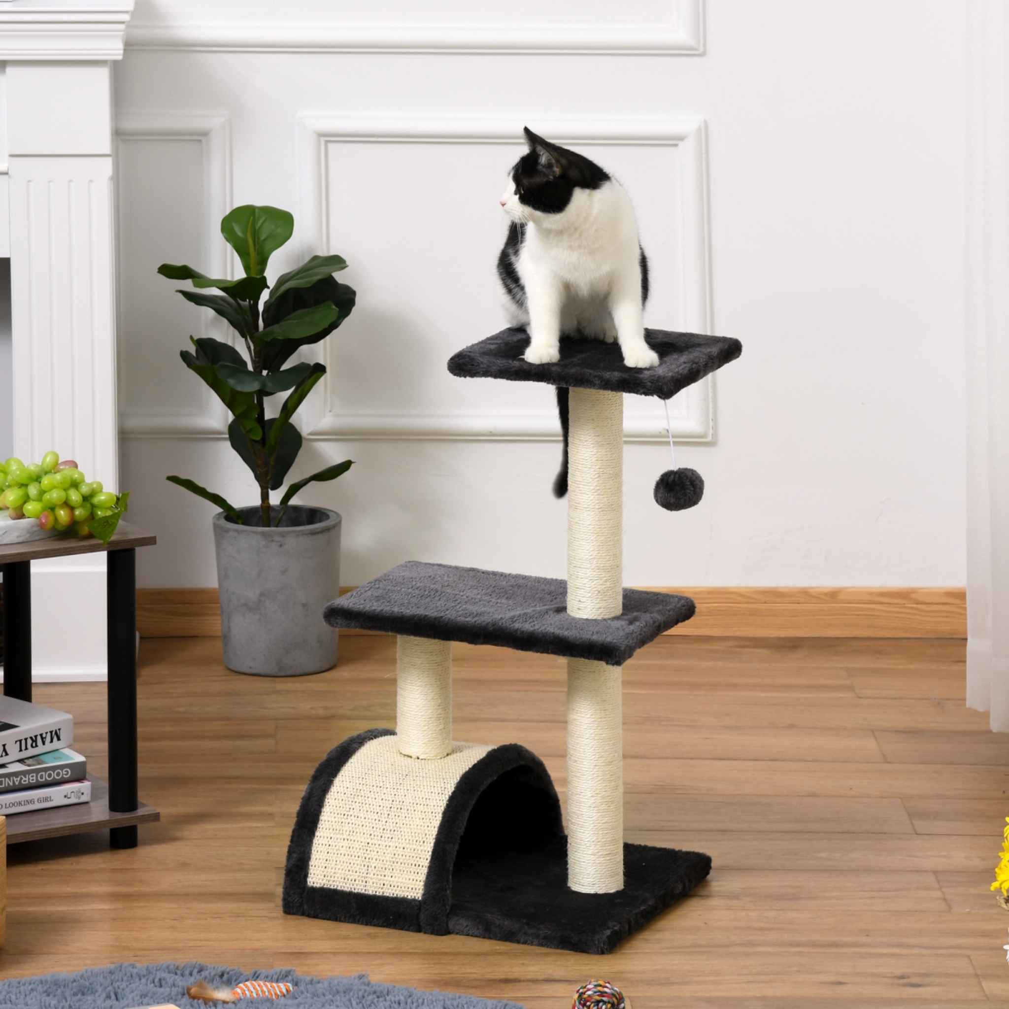 Cat sitting on top level of grey cat tower
