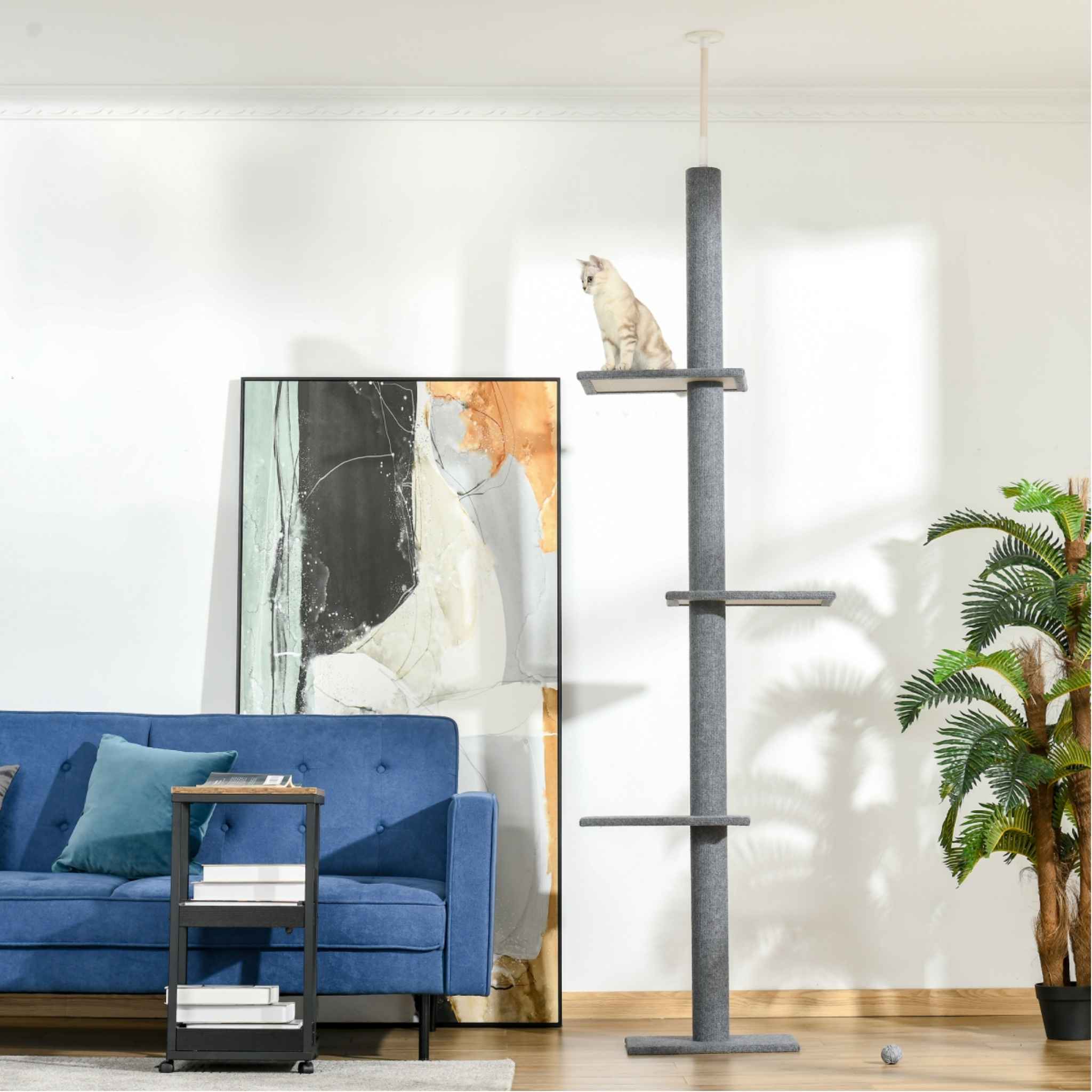 Cat sitting on top level of grey floor to ceiling cat tree