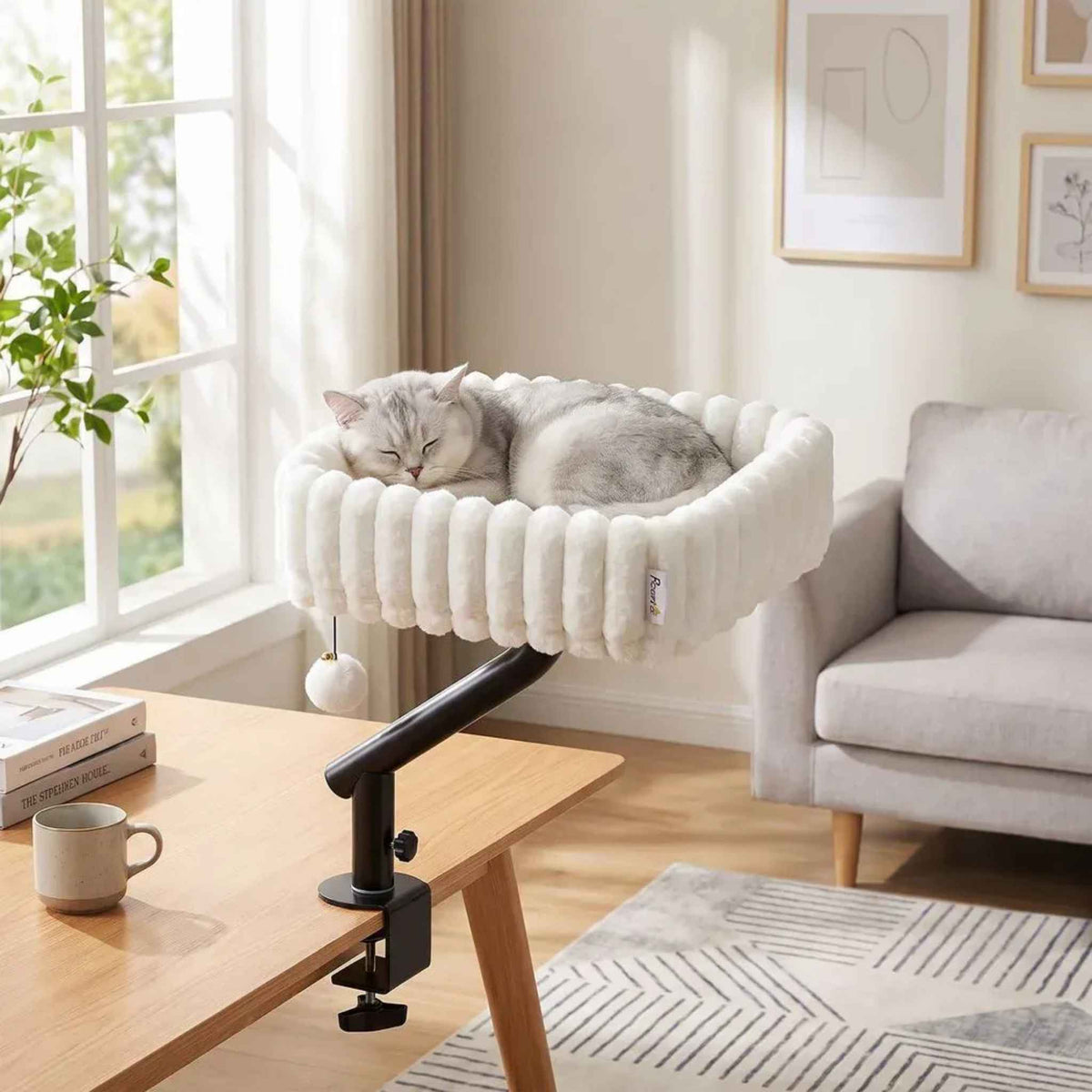 Cat sleeping in white bed attached to desk in office