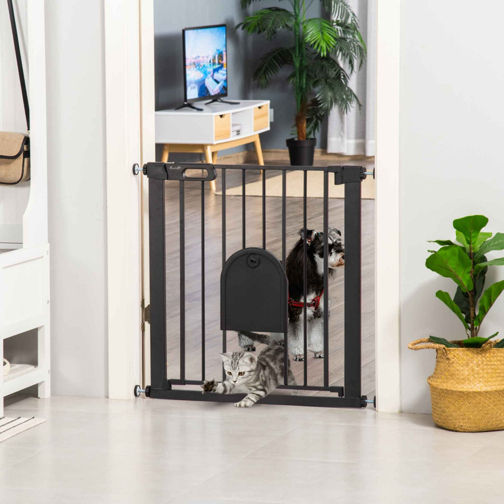 Cat walking through cat door on black pet gate