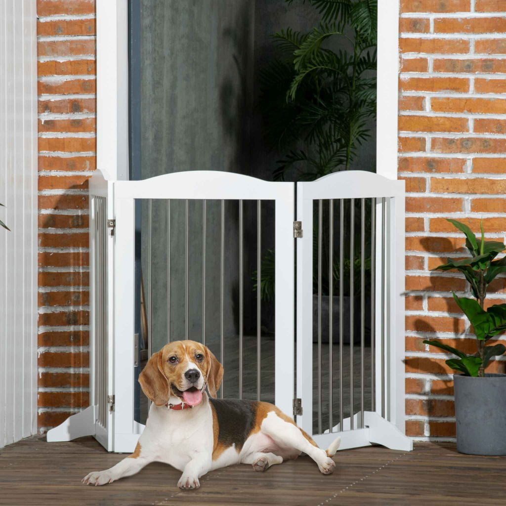 Dog laying in front of white freestanding pet gate