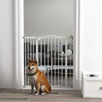 Dog sitting in front of tall white dog barrier in hallway