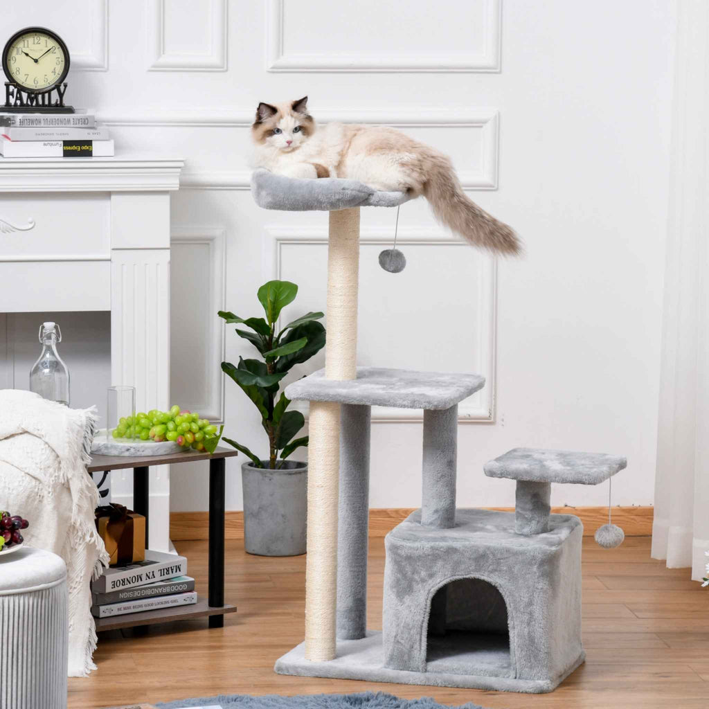 Grey cat tree in living room with cat on the top level