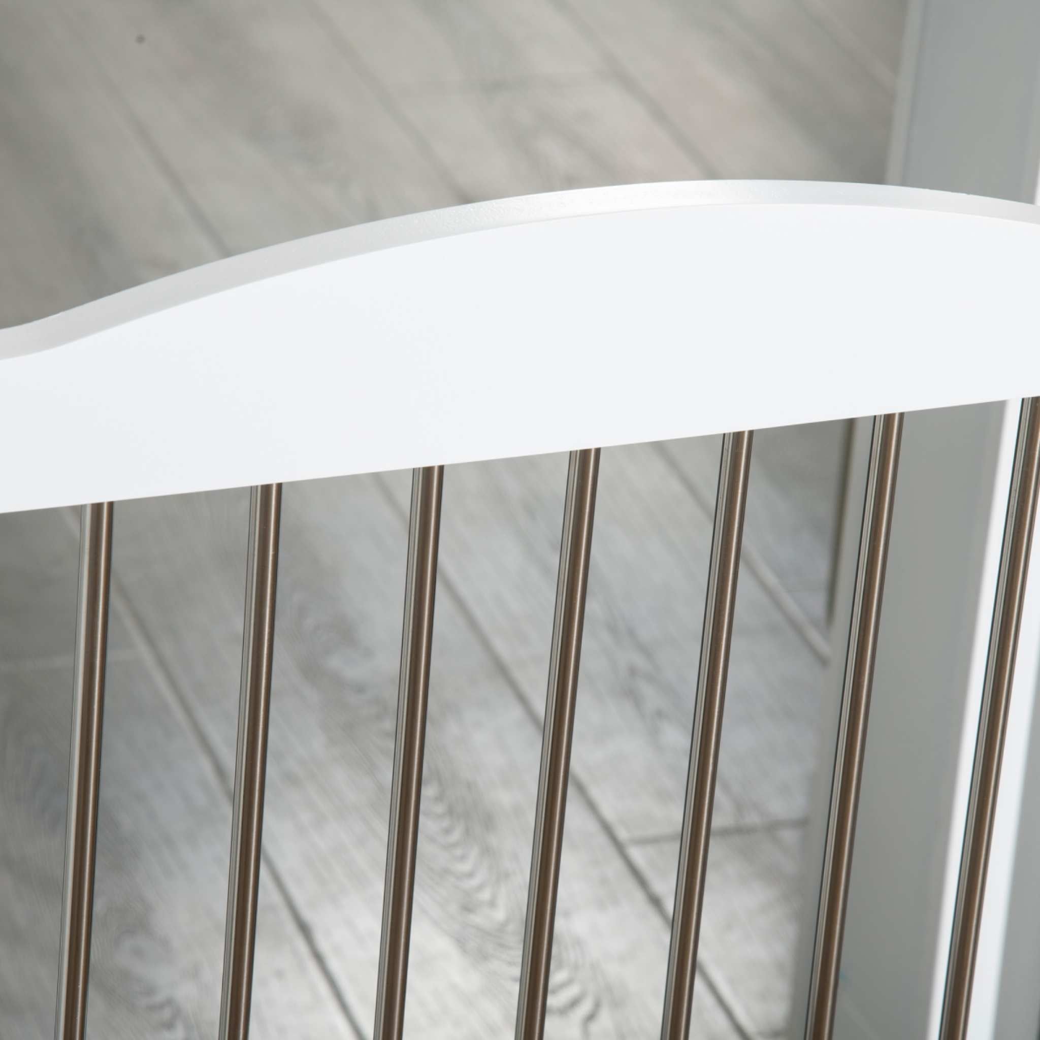 Metal bars on white freestanding pet gate