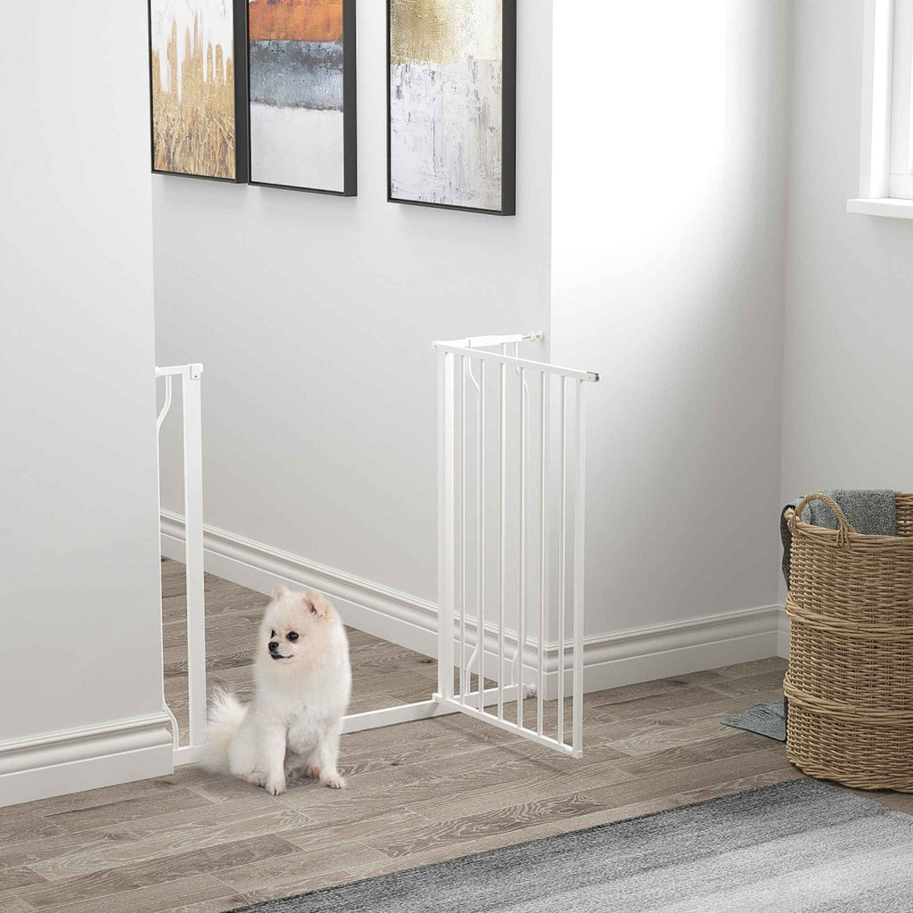 Small dog sitting in front of pet barrier in open position