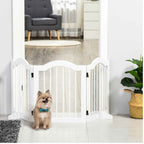 Small dog sitting in front of white freestanding pet gate