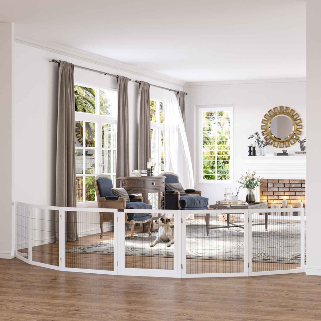 Small dog sitting in living room behind extra wide wooden dog barrier