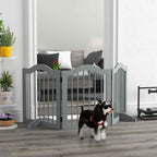 Small dog standing in front of grey freestanding dog gate in hallway