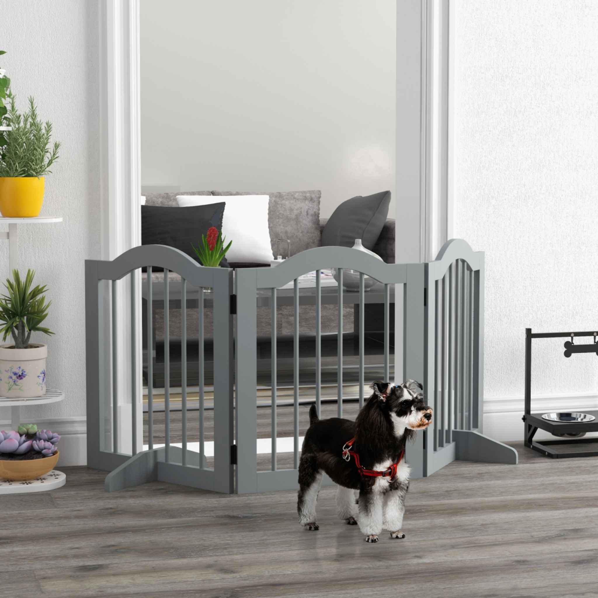 Small dog standing in front of grey freestanding dog gate in hallway