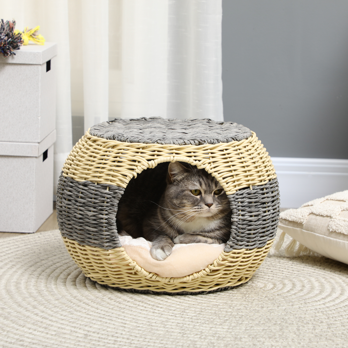 Tabby cat relaxing in enclosed rattan bed