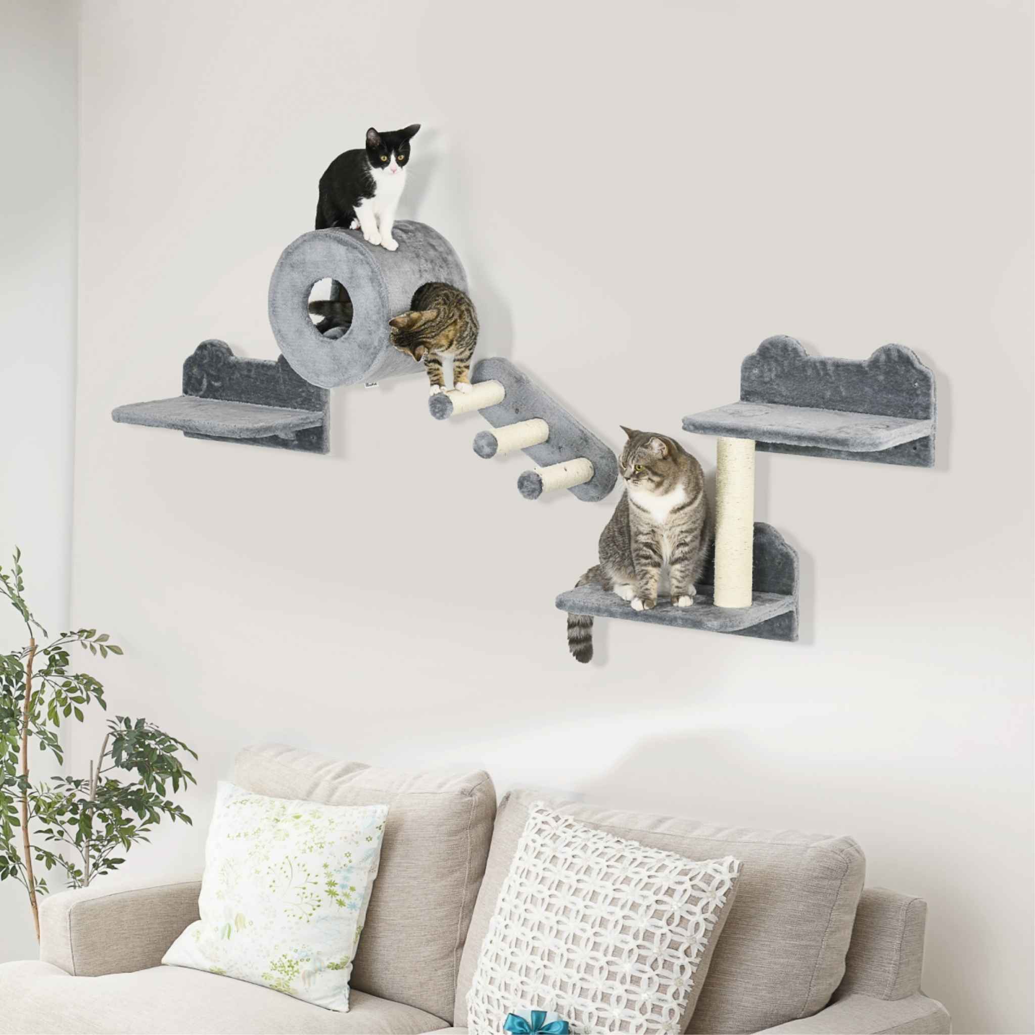 A wall-mounted cat tree with multiple platforms, a tunnel, and a scratching post, in a living room with three cats sitting on it