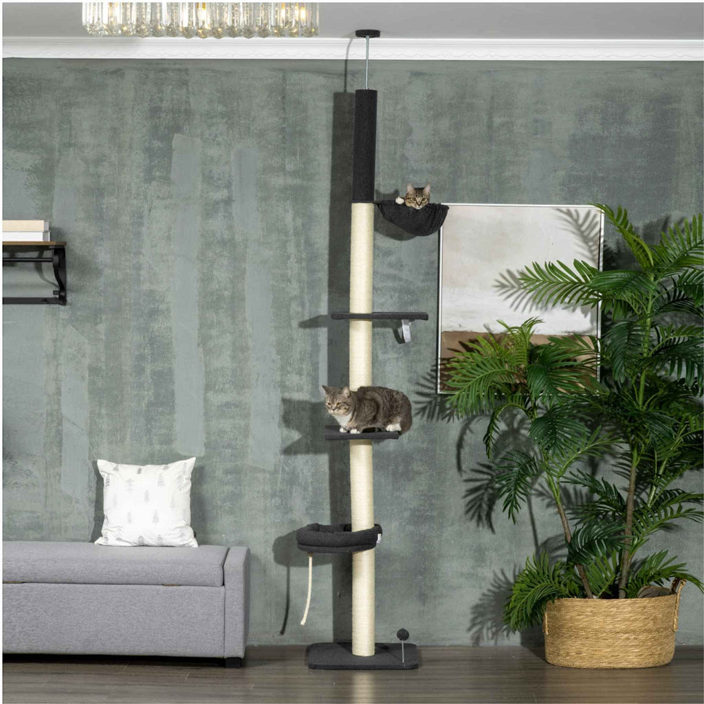 Two cats laying on different levels of black floor to ceiling cat tree
