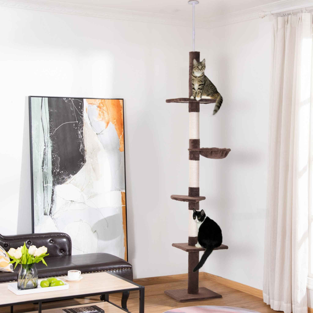 Two cats sitting on floor to ceiling cat tree tower